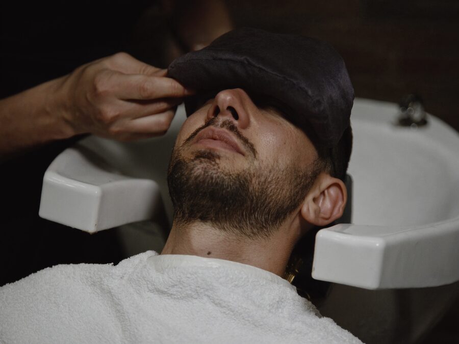 Eye mask and grooming tools on a dark towel still life